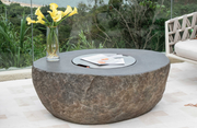 Boulder Stainless Steel Lid for fire pit table with a vase of yellow flowers on a patio