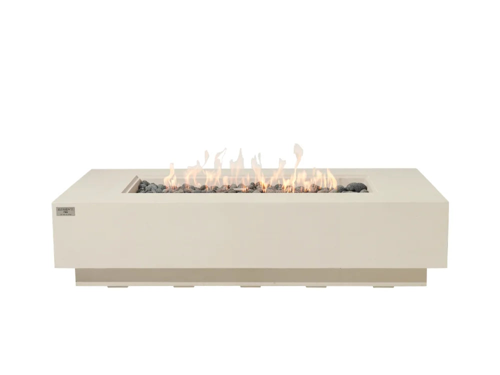 Elementi rectangular outdoor fire pit table with a matte cream white finish, featuring a lit flame effect over dark stones inside, shown against a solid white background.